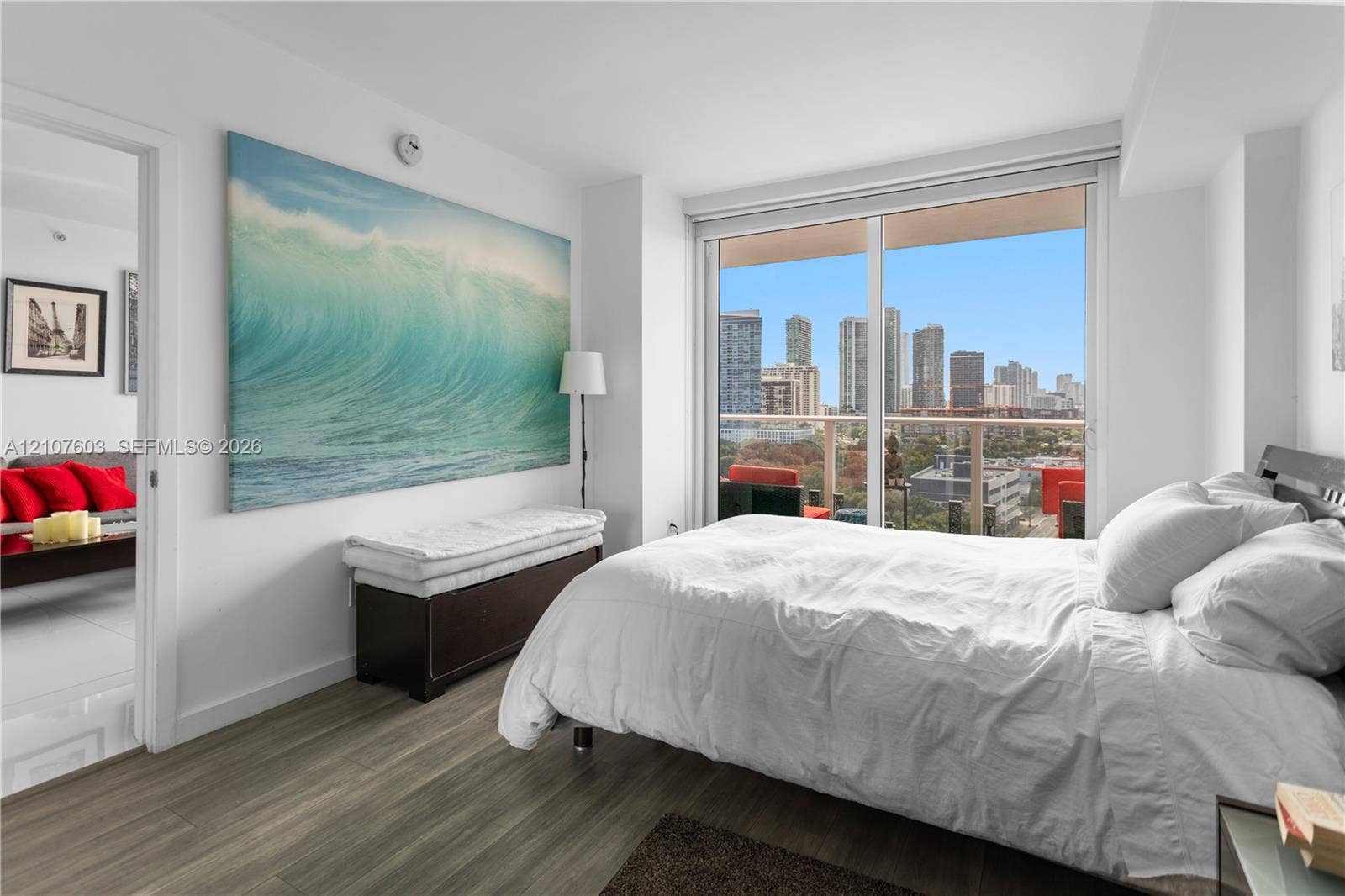 4250 Biscayne Boulevard, #1418, Miami, FL 33137 Floor-to-ceiling windows featuring a cityscape backdrop, private balcony with metal railing, and wood-finish flooring