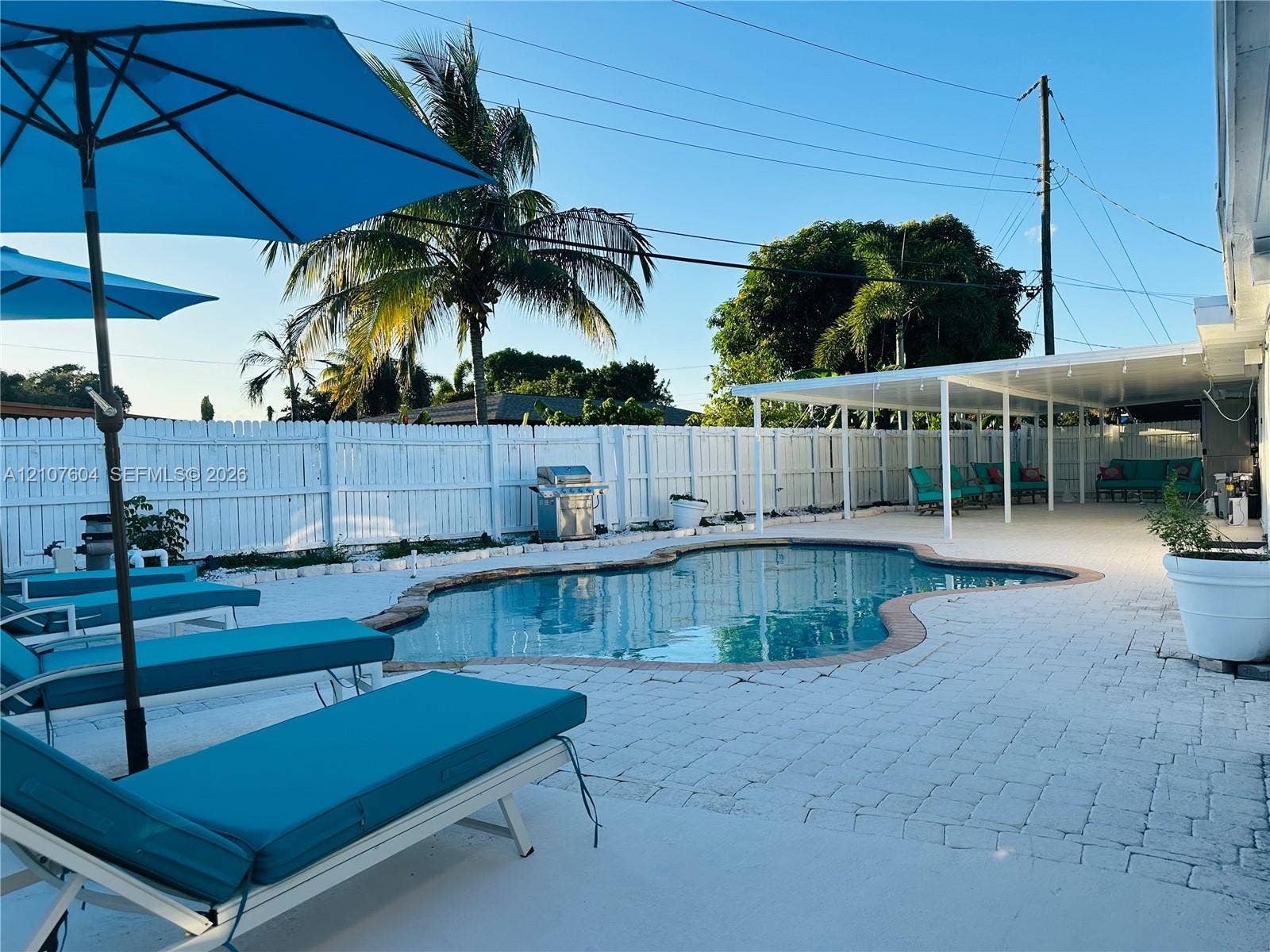 120 S 56th Avenue, Hollywood, Hollywood, FL 33023 Backyard featuring an in-ground swimming pool, stone paver decking, covered patio, and perimeter privacy fencing