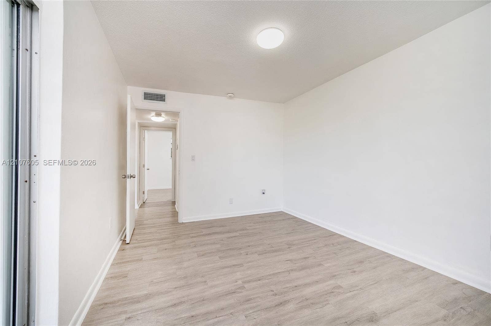 444 SW 27th Avenue, #42, Miami, Miami, FL 33135 Room featuring light-toned wood-finish flooring, neutral walls, and a circular flush-mount ceiling light fixture