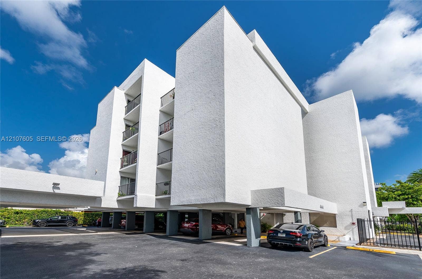 444 SW 27th Avenue, #42, Miami, Miami, FL 33135 Multi-story architectural exterior featuring a textured white finish, covered ground-level parking, and stacked balconies