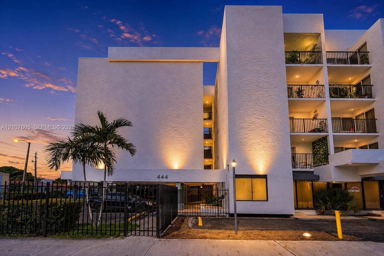 444 SW 27th Avenue, #42, Miami, Miami, FL 33135 Multi-story stucco exterior featuring stacked private balconies, black metal railings, and a gated parking entrance
