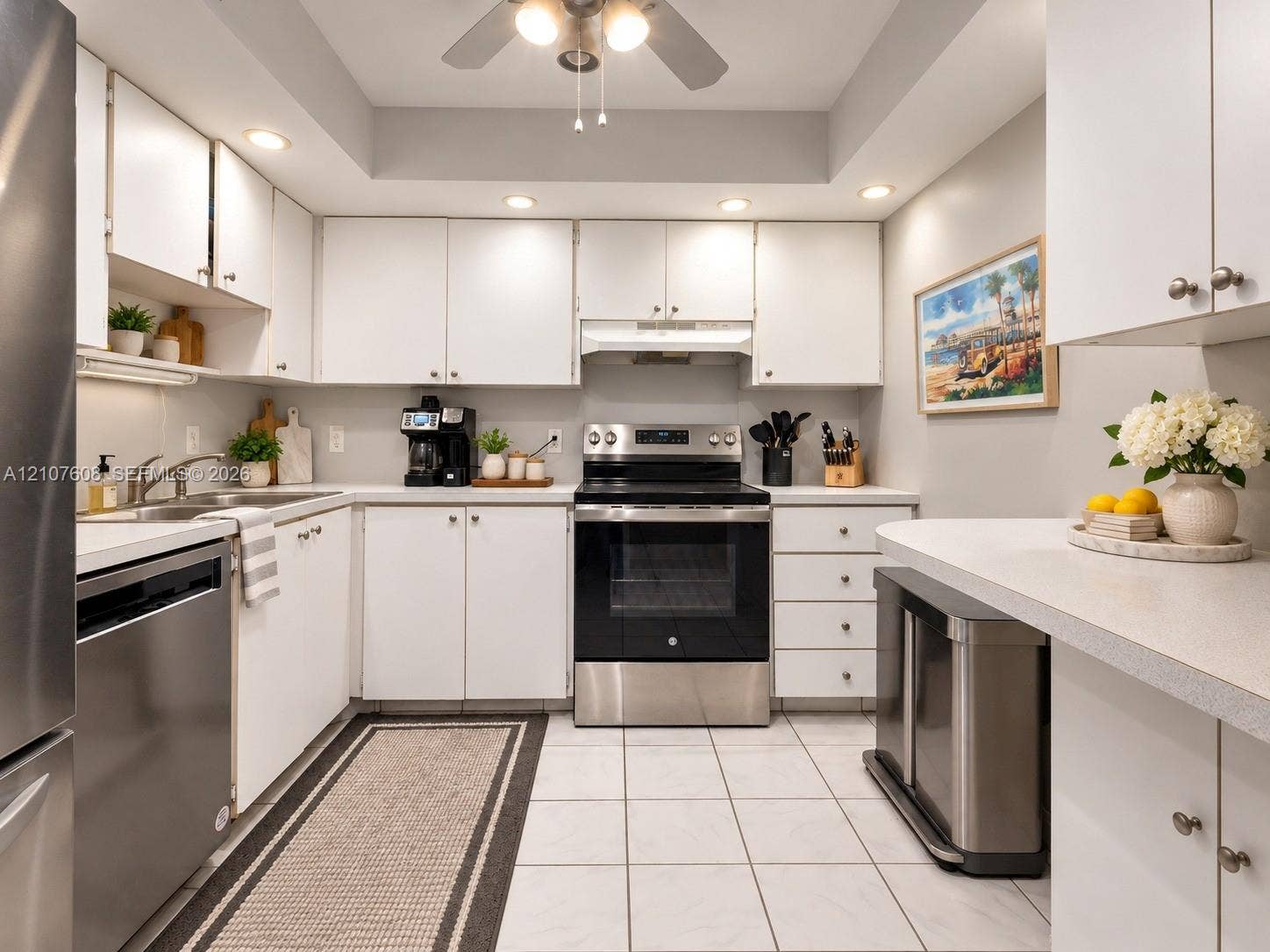 2000 S Ocean Boulevard, #12F, Lauderdale-By-The-Sea, Lauderdale By The Sea, FL 33062 Kitchen featuring white shaker-style cabinetry, stainless steel appliances, recessed ceiling lighting, light-toned tiled flooring, and a peninsula countertop
