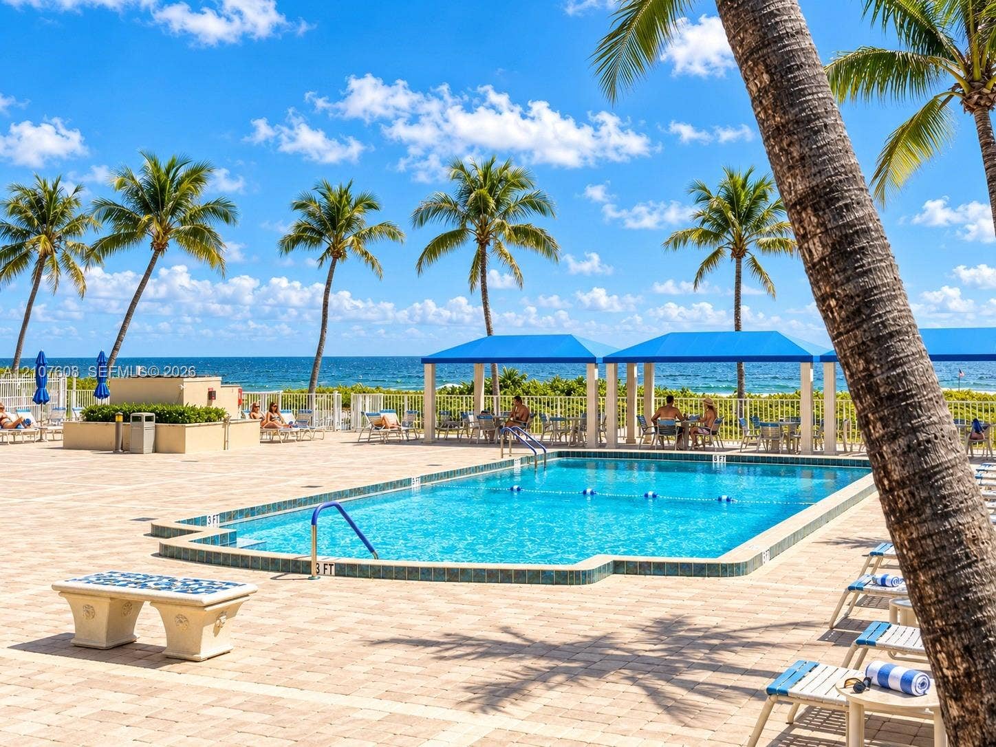2000 S Ocean Boulevard, #12F, Lauderdale-By-The-Sea, Lauderdale By The Sea, FL 33062 Swimming pool with tile edging, surrounding paver patio, and multiple blue-canopy cabanas situated near the coastline