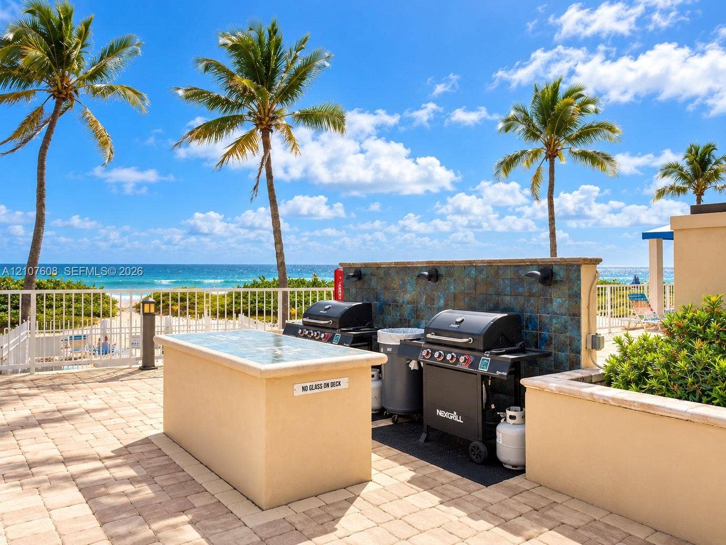 2000 S Ocean Boulevard, #12F, Lauderdale-By-The-Sea, Lauderdale By The Sea, FL 33062 Outdoor patio featuring paver flooring, a stucco-finish built-in prep island with a stone surface, tiled backsplash, and metal perimeter fencing