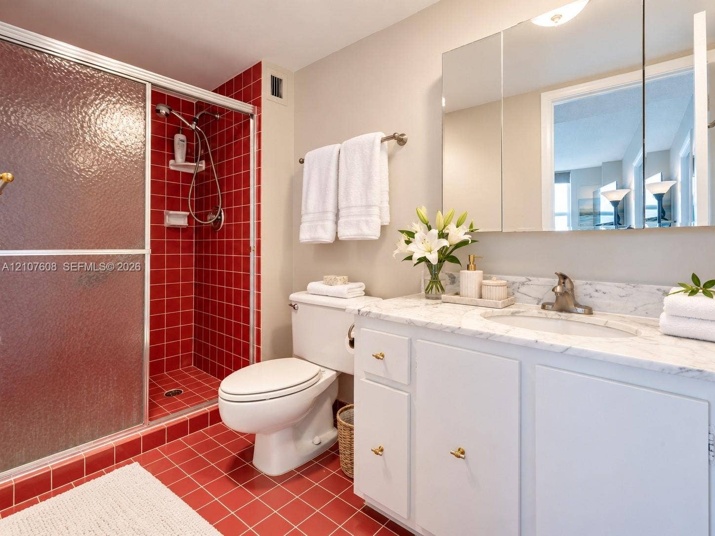 2000 S Ocean Boulevard, #12F, Lauderdale-By-The-Sea, Lauderdale By The Sea, FL 33062 Vanity with stone countertop and integrated oval sink, built-in medicine cabinet, walk-in shower with textured glass door, and tiled flooring