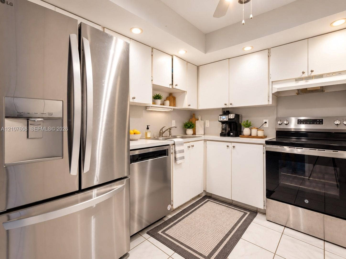 2000 S Ocean Boulevard, #12F, Lauderdale-By-The-Sea, Lauderdale By The Sea, FL 33062 Kitchen featuring white cabinetry, stainless steel appliances, recessed ceiling lighting, solid-surface countertops, and tile flooring