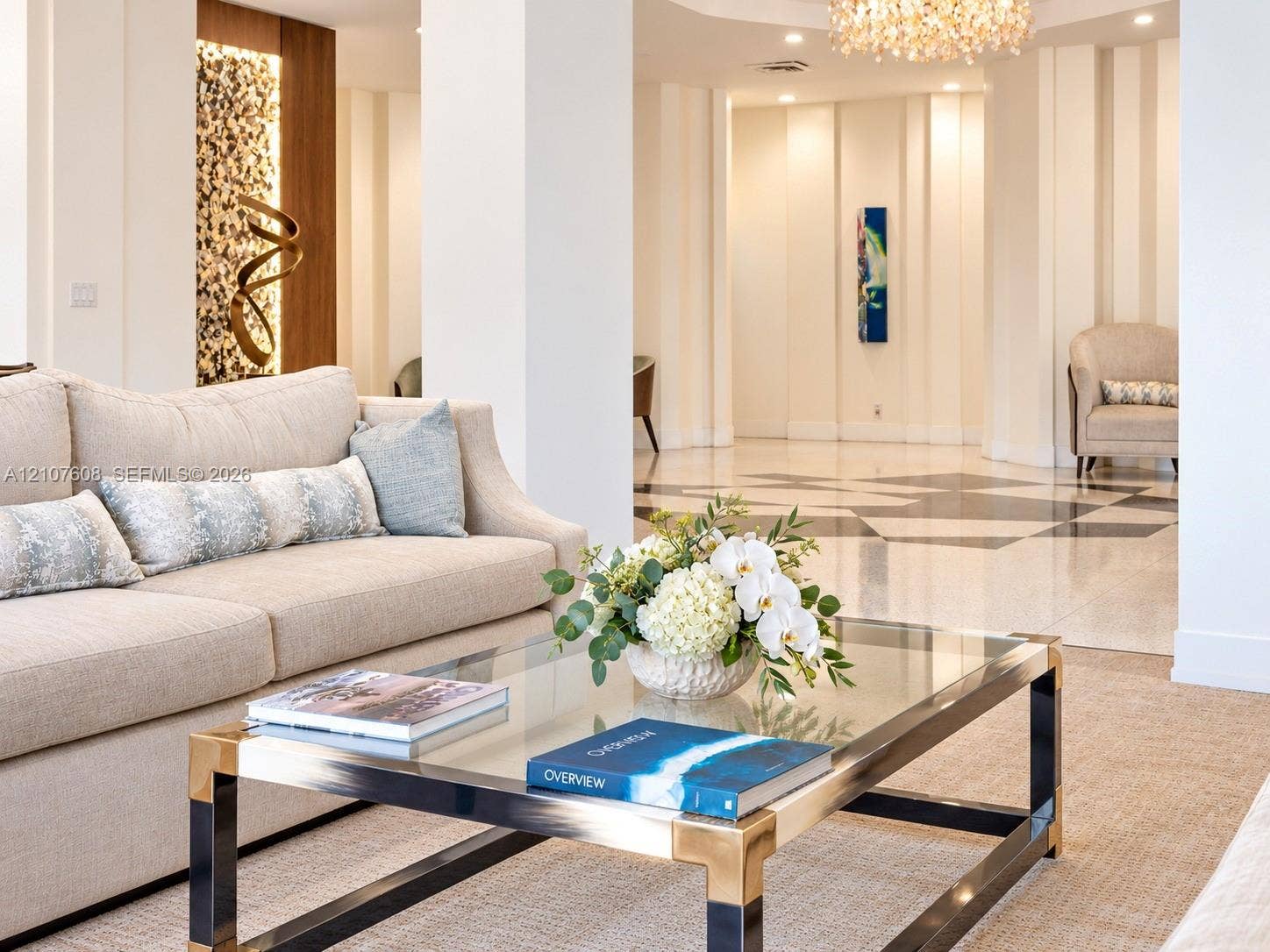 2000 S Ocean Boulevard, #12F, Lauderdale-By-The-Sea, Lauderdale By The Sea, FL 33062 Spacious interior featuring geometric patterned stone flooring, vertical wall paneling, integrated recessed accent lighting, and a crystal chandelier