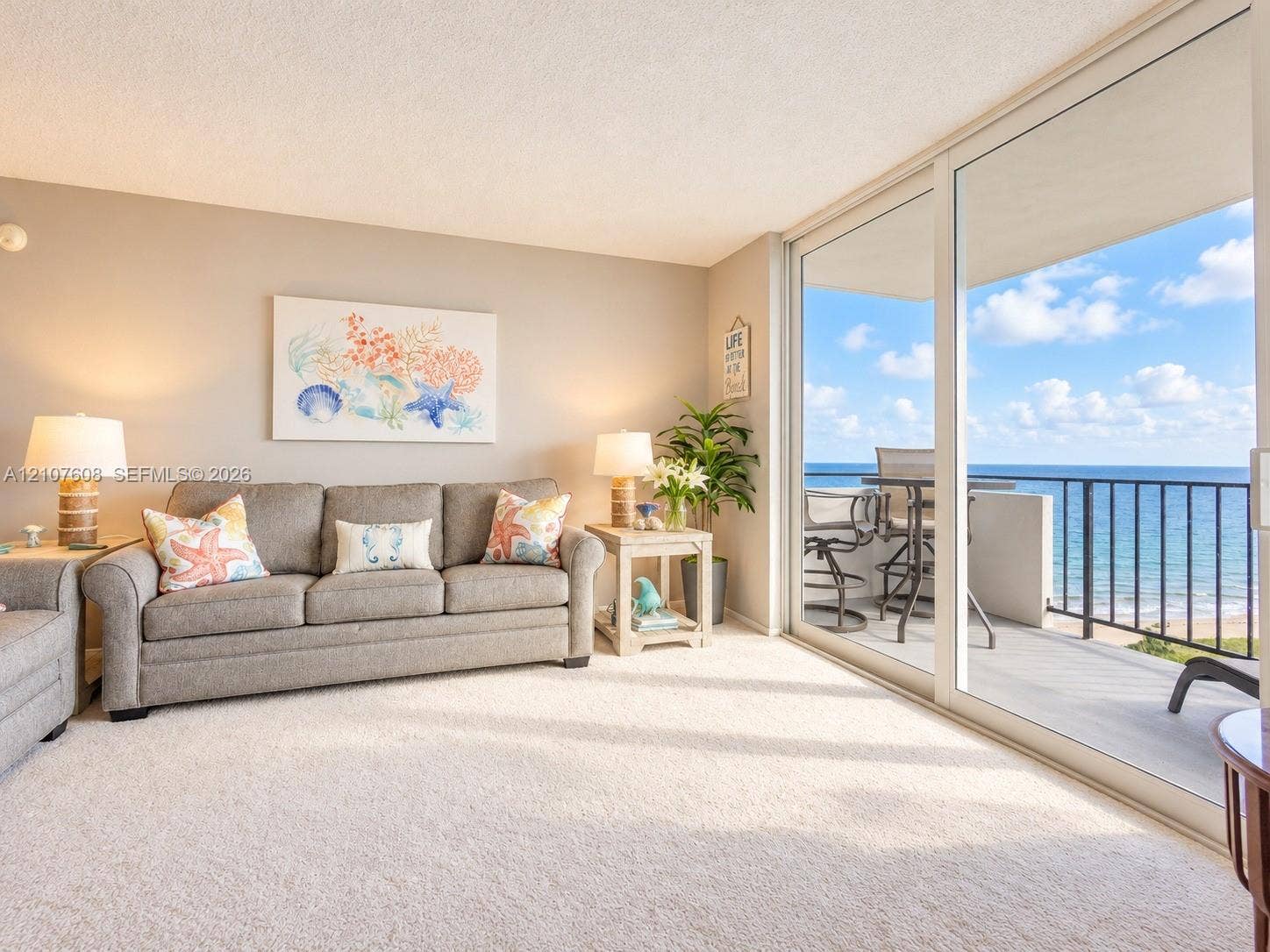 2000 S Ocean Boulevard, #12F, Lauderdale-By-The-Sea, Lauderdale By The Sea, FL 33062 Living area featuring wall-to-wall carpeting and floor-to-ceiling sliding glass doors opening to a balcony with metal railings and coastal surroundings