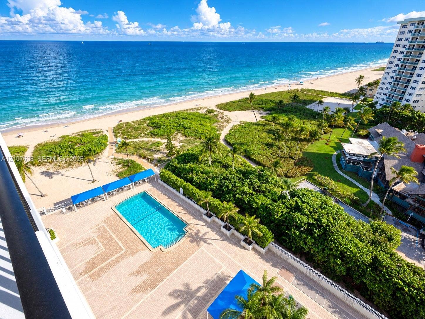 2000 S Ocean Boulevard, #12F, Lauderdale-By-The-Sea, Lauderdale By The Sea, FL 33062 Oceanfront balcony featuring a rectangular swimming pool, paver deck, permanent shade structures, and manicured landscaping