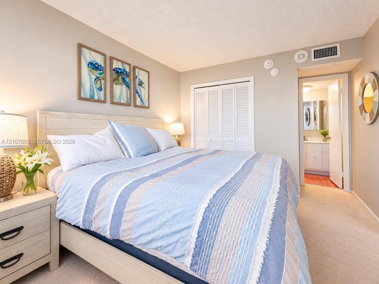 2000 S Ocean Boulevard, #12F, Lauderdale-By-The-Sea, Lauderdale By The Sea, FL 33062 Neutral wall tones featuring carpeting, a double-door louvered closet, and an entry to an en-suite bathroom with a vanity