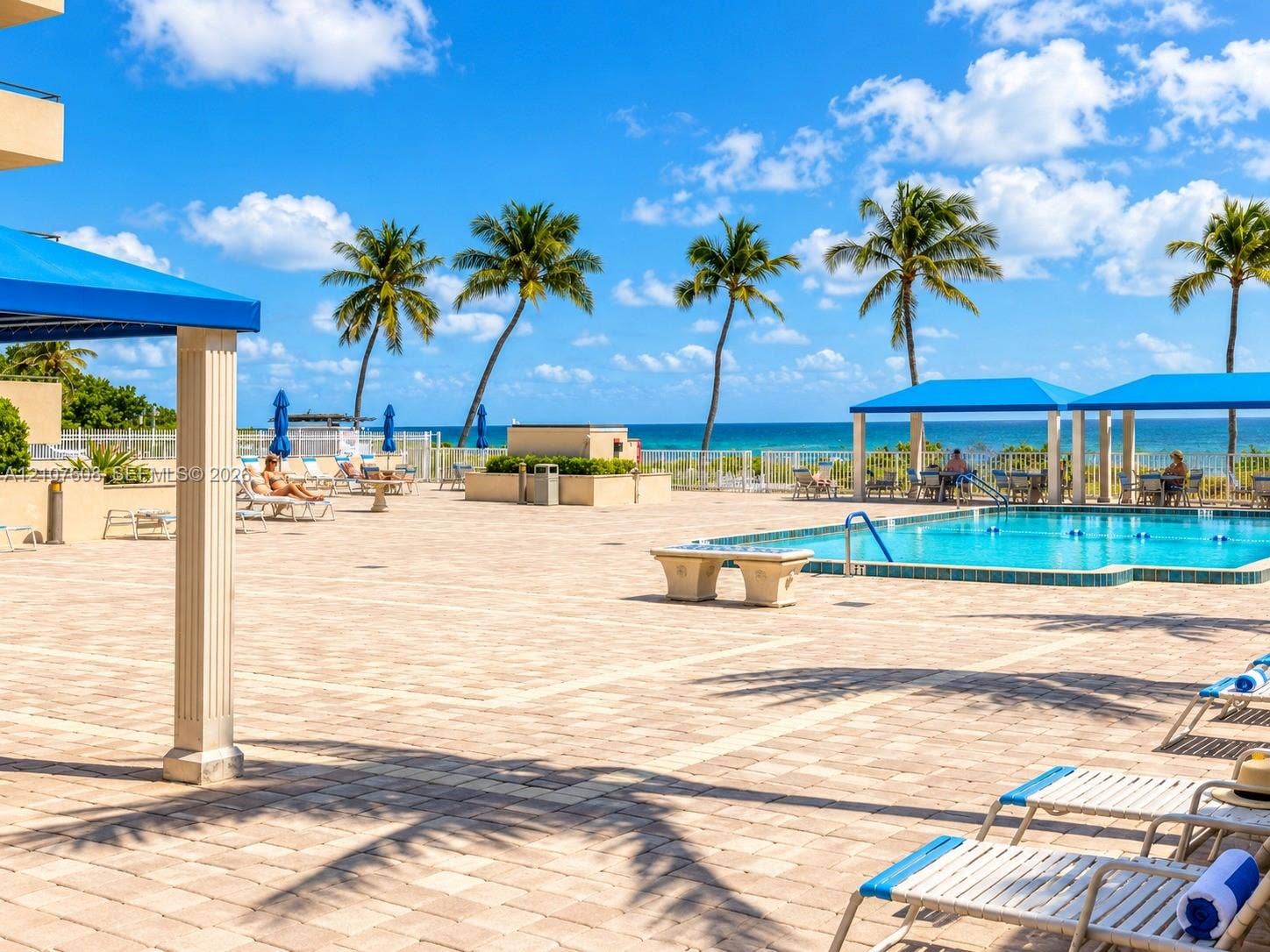 2000 S Ocean Boulevard, #12F, Lauderdale-By-The-Sea, Lauderdale By The Sea, FL 33062 Paver pool deck with a swimming pool, shaded structural pavilions, and ocean backdrop
