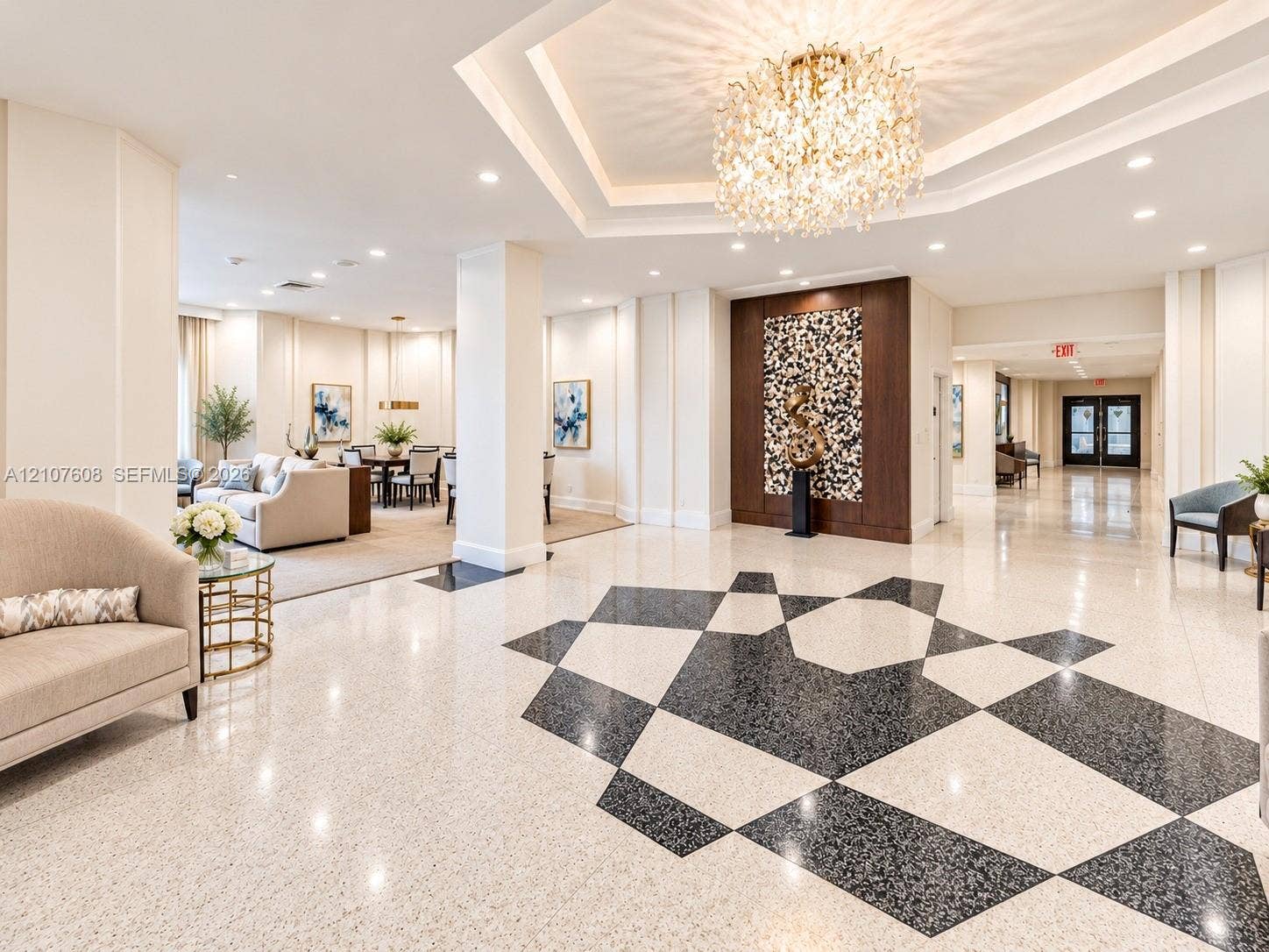 2000 S Ocean Boulevard, #12F, Lauderdale-By-The-Sea, Lauderdale By The Sea, FL 33062 Grand lobby featuring geometric patterned terrazzo flooring, a coffered tray ceiling, a central crystal chandelier, and a decorative wood-paneled accent wall