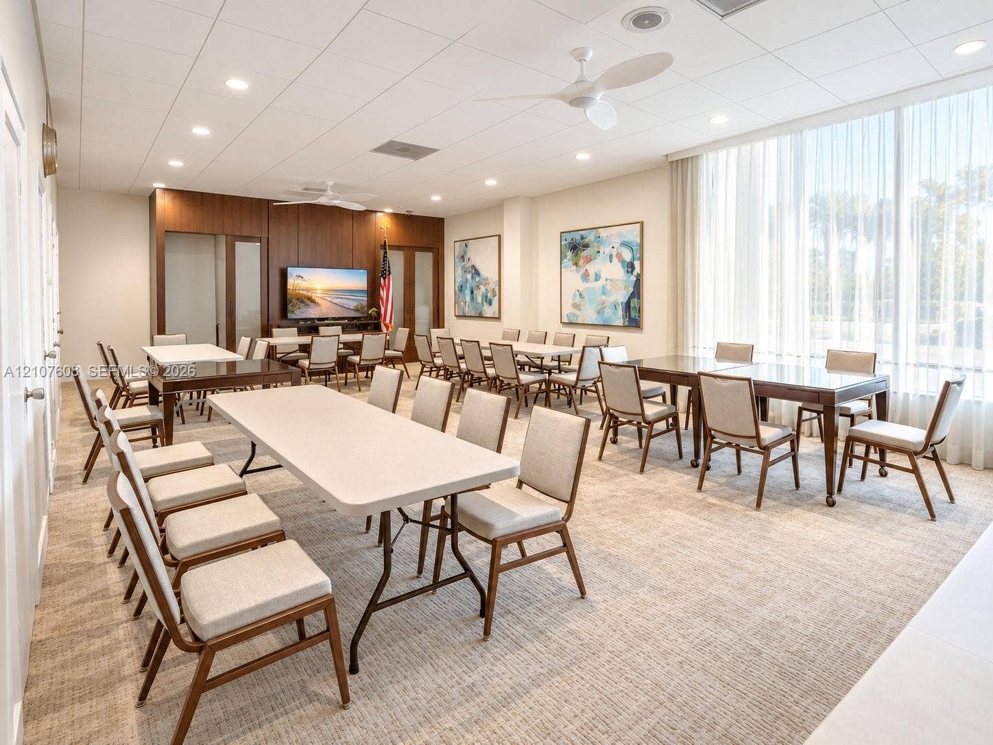 2000 S Ocean Boulevard, #12F, Lauderdale-By-The-Sea, Lauderdale By The Sea, FL 33062 Spacious common room featuring floor-to-ceiling windows with sheer drapery, recessed ceiling lighting, dual ceiling fans, wood-paneled accent wall, and neutral carpeting