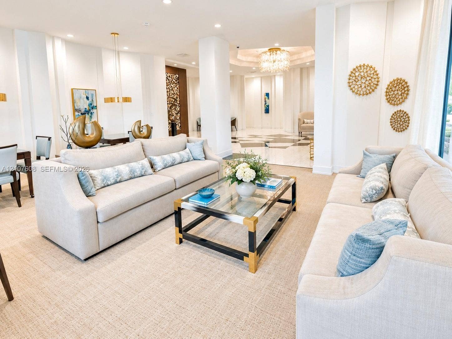 2000 S Ocean Boulevard, #12F, Lauderdale-By-The-Sea, Lauderdale By The Sea, FL 33062 Open-concept common area featuring high ceilings, structural columns, intricate chandelier lighting, and a patterned stone floor