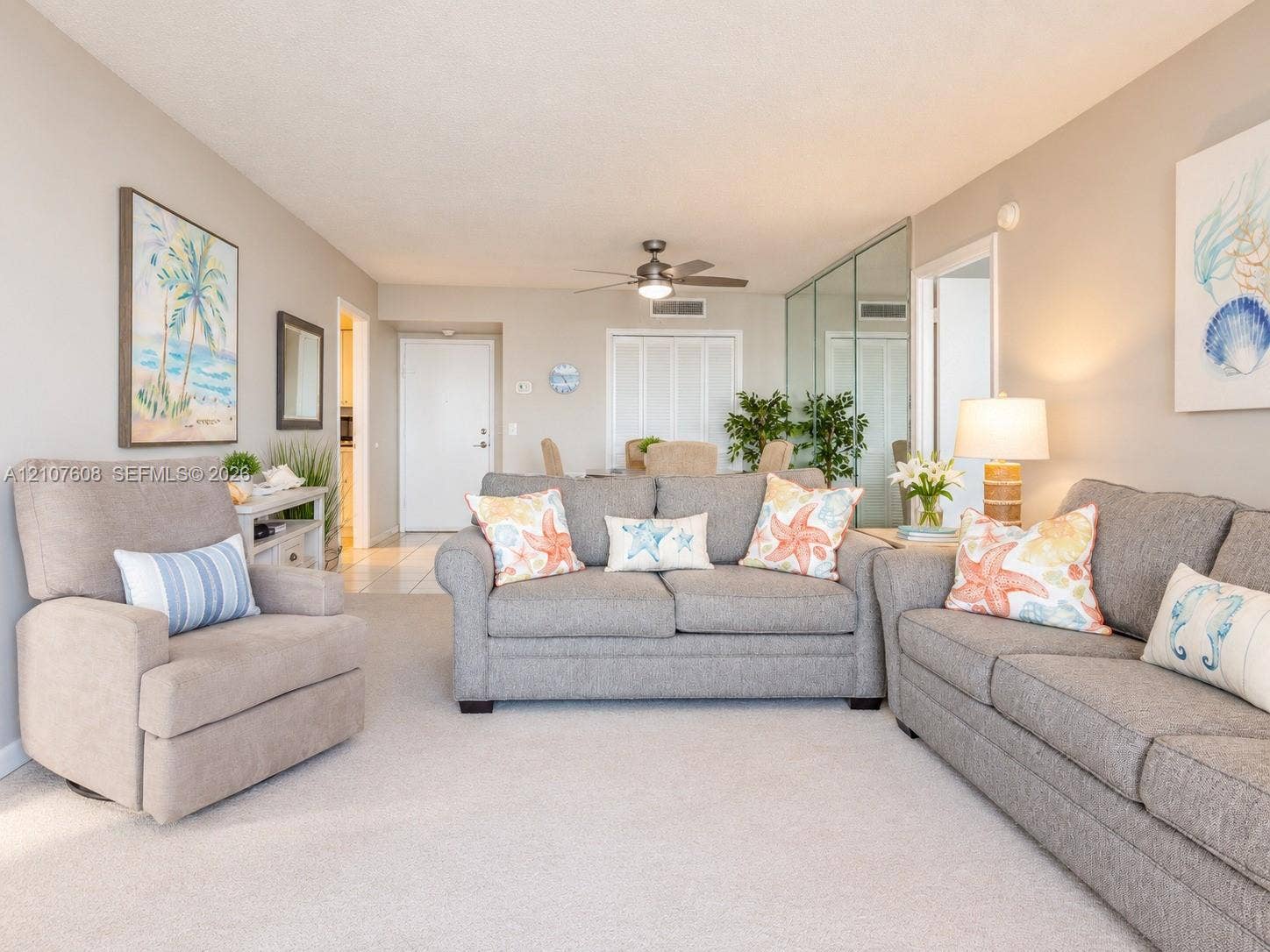 2000 S Ocean Boulevard, #12F, Lauderdale-By-The-Sea, Lauderdale By The Sea, FL 33062 Neutral-toned interior featuring wall-to-wall carpeting, mirrored closet doors, a central ceiling fan with integrated lighting, and multiple louvered-door closets