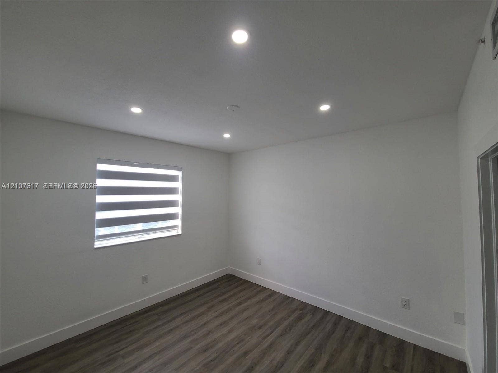 17415 NW 75th Place, #103, Hialeah, Hialeah, FL 33015 Neutral-toned room featuring wood-finish flooring, recessed lighting, and a window with adjustable roller shades