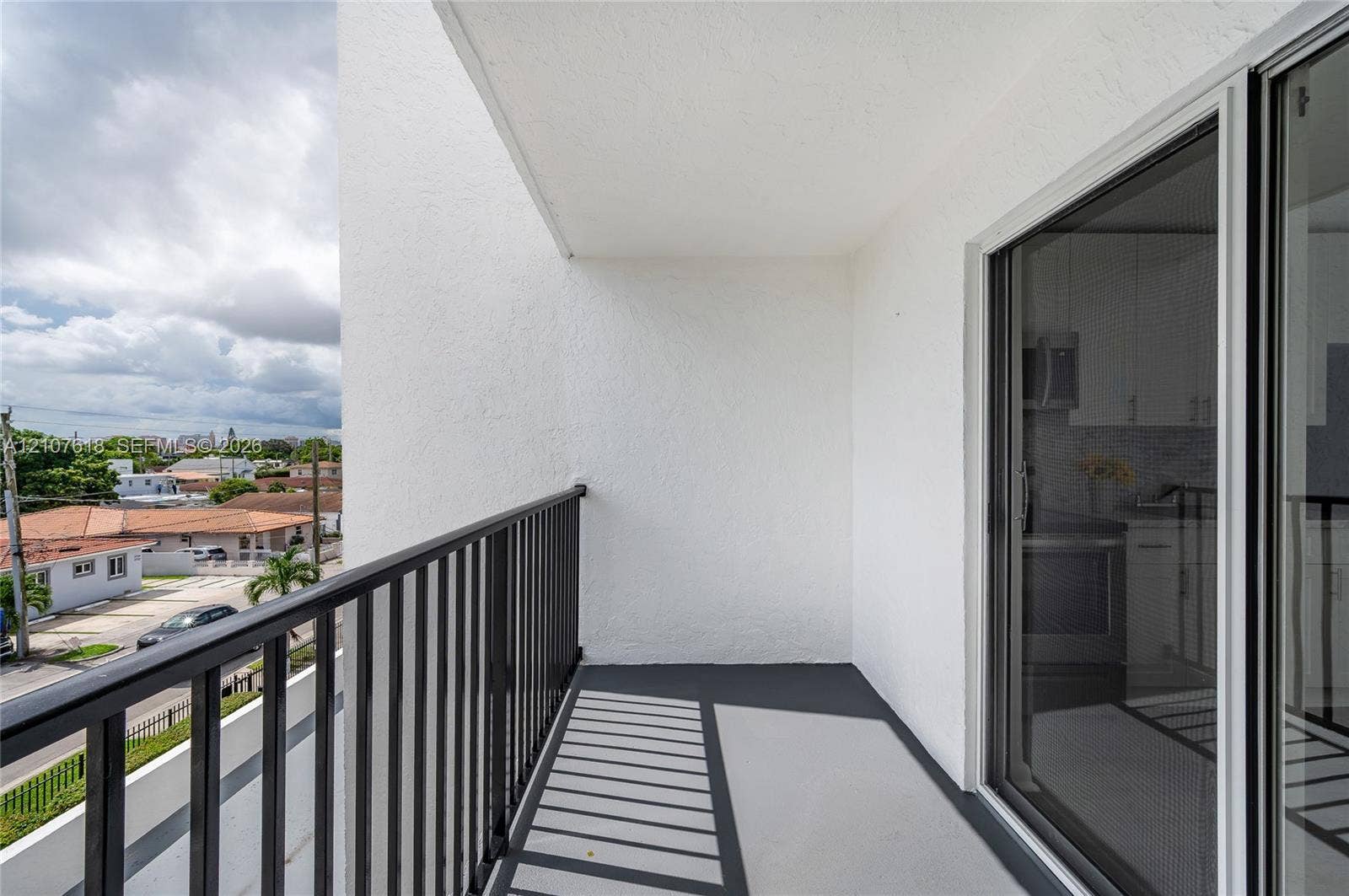 444 SW 27th Avenue, #46, Miami, Miami, FL 33135 Private balcony featuring smooth stucco walls, concrete flooring, and black metal railings