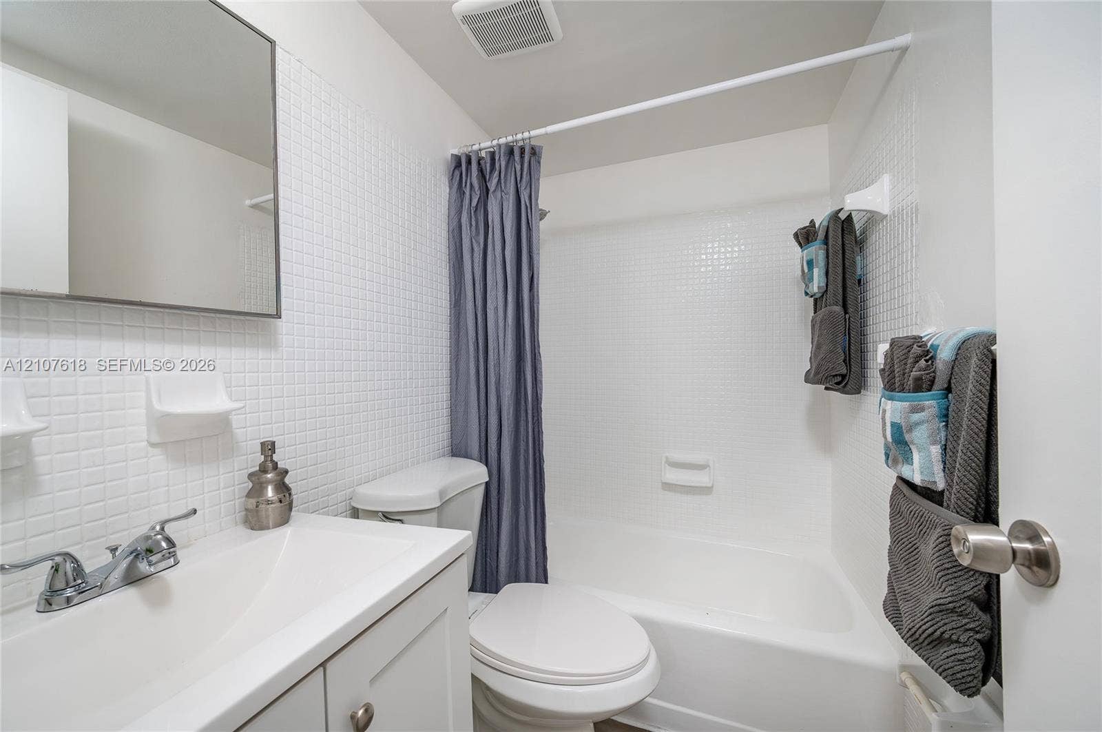 444 SW 27th Avenue, #46, Miami, Miami, FL 33135 Bathroom featuring a white vanity cabinet, rectangular undermount sink, chrome faucet, tiled wall surfacing, and a built-in shower and tub combination