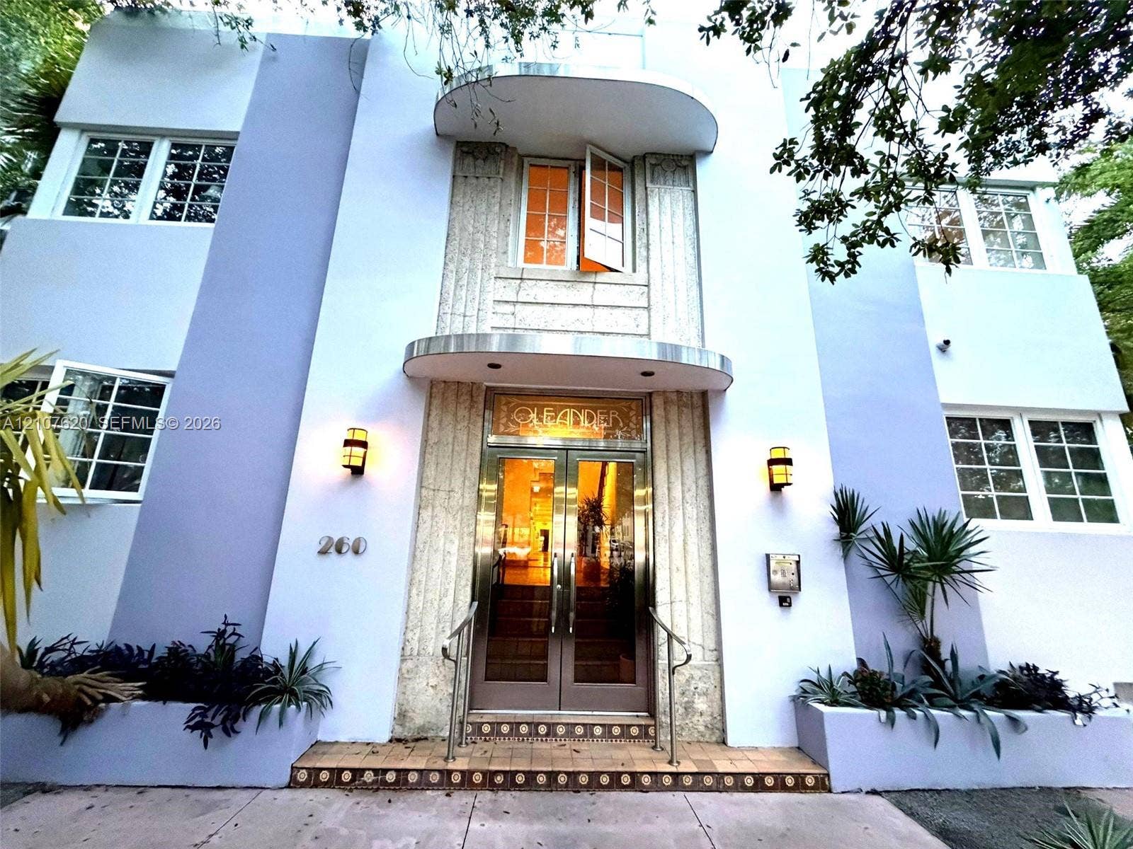 260 Euclid Avenue, #29, Miami Beach, Miami Beach, FL 33139 Art Deco facade featuring geometric stonework, a stepped entrance with decorative tile detailing, double-glass entry doors, integrated wall-mounted lighting, and metal awnings