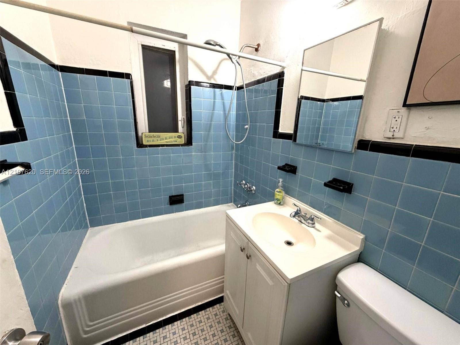 260 Euclid Avenue, #29, Miami Beach, Miami Beach, FL 33139 Bathroom featuring blue square wall tiles with black trim, porcelain tub with shower head, vanity cabinet with integrated sink, and mosaic tile flooring
