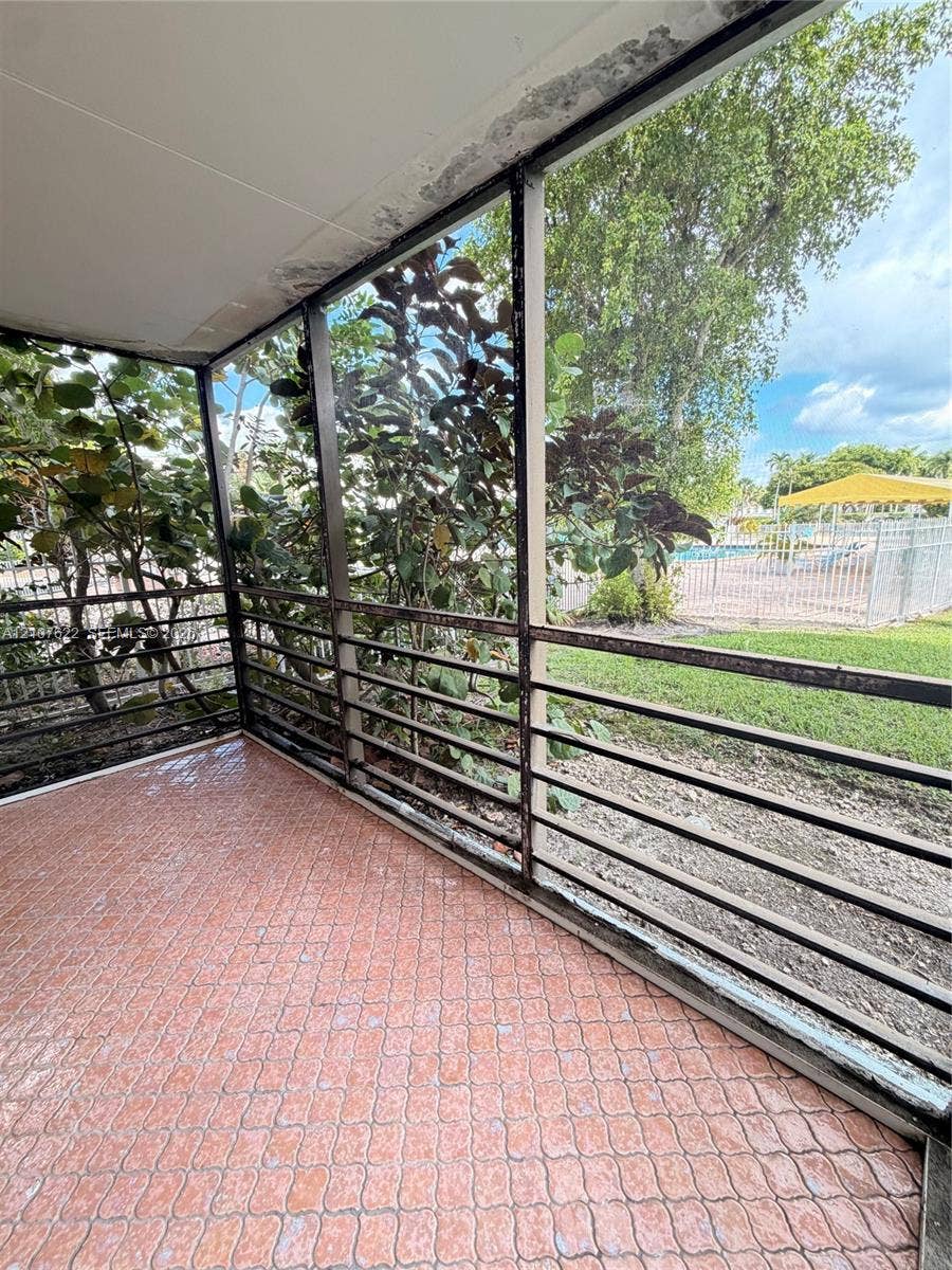 20400 W Country Club Drive, #112, Aventura, FL 33180 Screened-in porch featuring patterned tile flooring and a metal frame enclosure