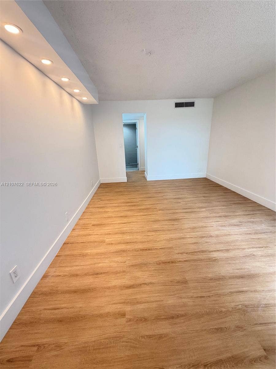 20400 W Country Club Drive, #112, Aventura, FL 33180 Interior space featuring wood-finish flooring, recessed lighting within a soffit, and smooth wall finishes