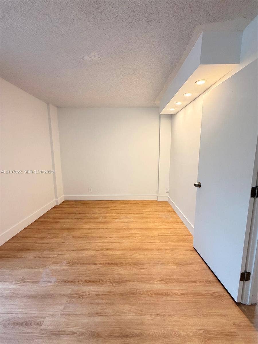 20400 W Country Club Drive, #112, Aventura, FL 33180 Room featuring wood-finish flooring, recessed lighting, and a soffit ceiling detail