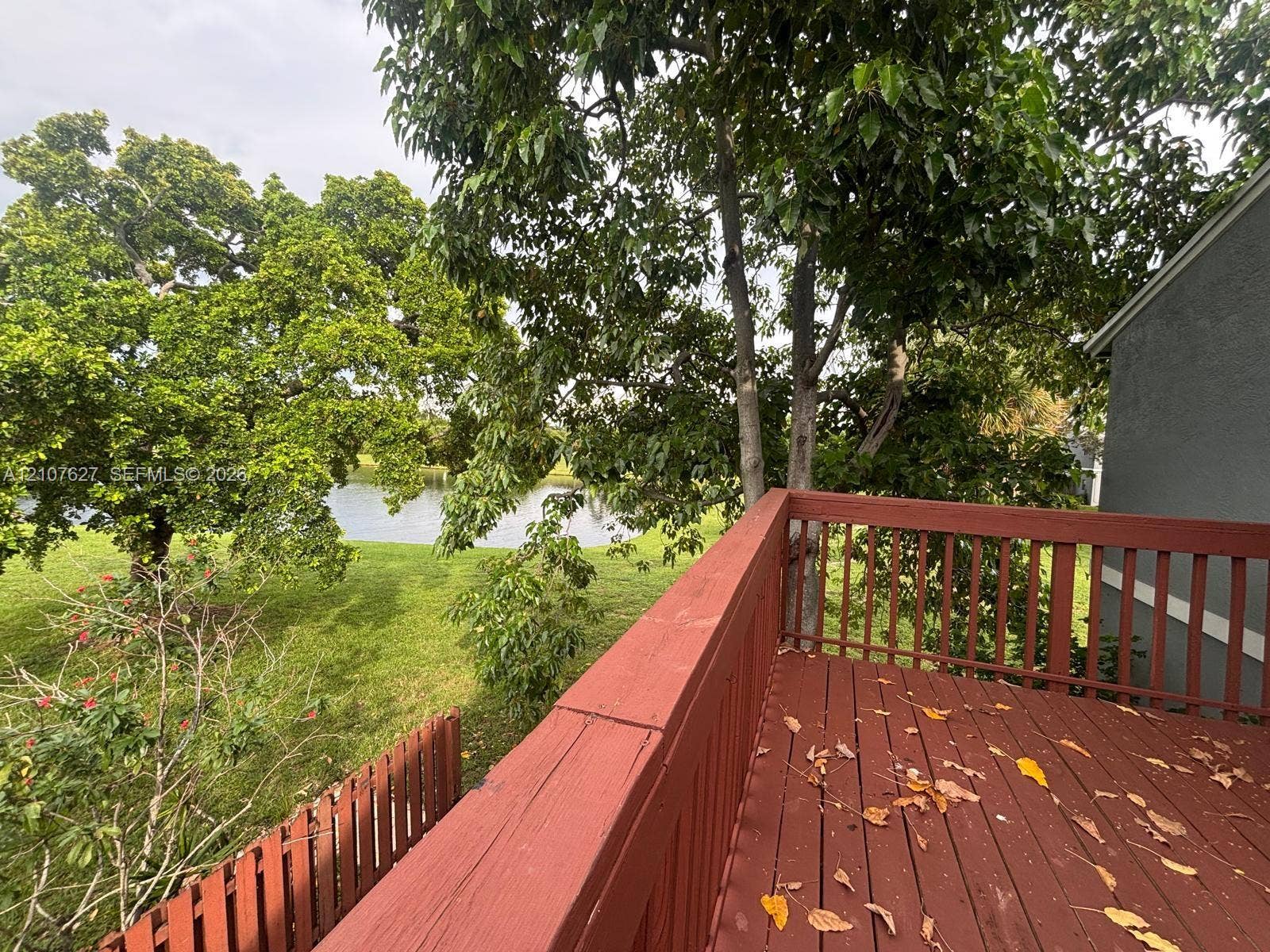 19 Crossings Circle, #H, Boynton Beach, Boynton Beach, FL 33435 Raised wood deck featuring a railing and open outdoor space, overlooking a pond and mature trees