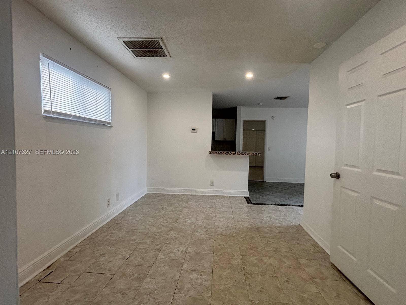 19 Crossings Circle, #H, Boynton Beach, Boynton Beach, FL 33435 Neutral-toned tile flooring, recessed lighting, horizontal window blinds, and a built-in kitchen pass-through counter