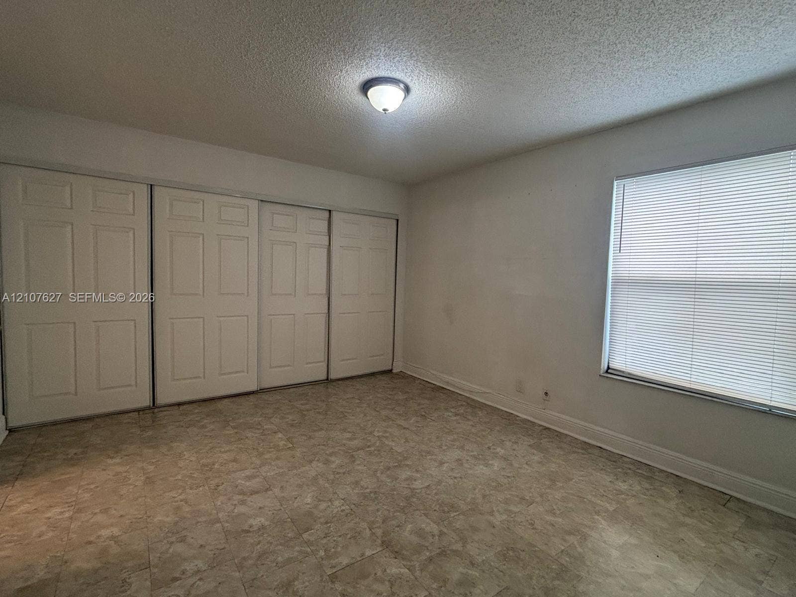 19 Crossings Circle, #H, Boynton Beach, Boynton Beach, FL 33435 Room featuring tile flooring, four-panel sliding closet doors, and an adjustable window blind