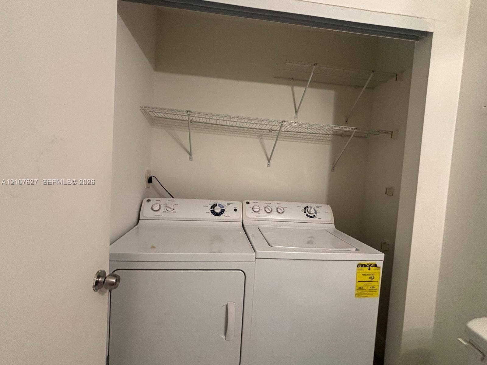 19 Crossings Circle, #H, Boynton Beach, Boynton Beach, FL 33435 Laundry closet featuring white top-load washer and dryer, mounted wire shelving, and neutral wall finish