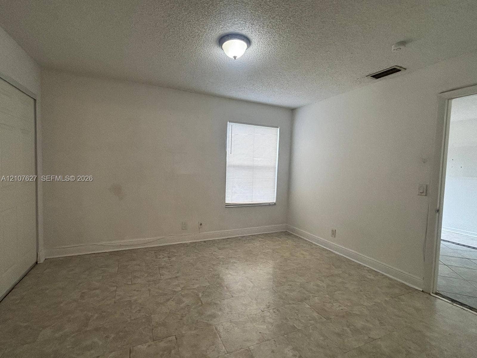 19 Crossings Circle, #H, Boynton Beach, Boynton Beach, FL 33435 Room featuring neutral wall finishes, tile flooring, a window with horizontal blinds, and a built-in closet with sliding doors