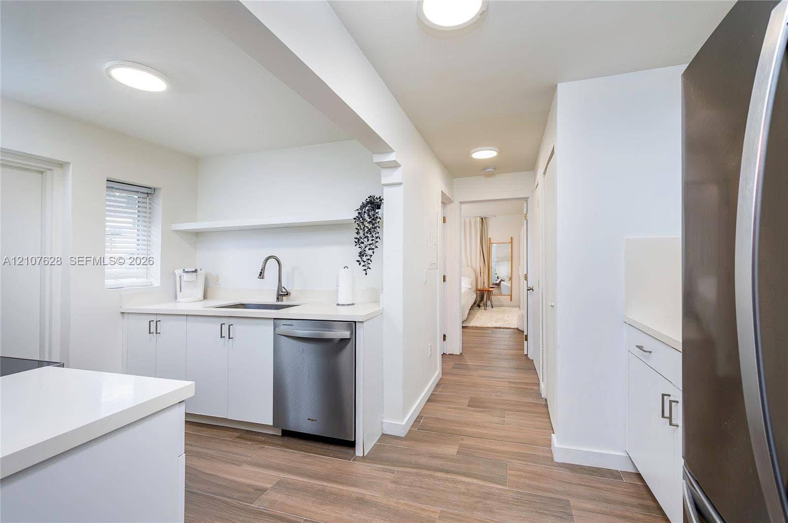 217 Madeira Avenue, #1, Coral Gables, Coral Gables, FL 33134 Kitchen featuring white cabinetry, solid-surface countertops, stainless steel dishwasher, wood-finish flooring, and recessed ceiling lighting