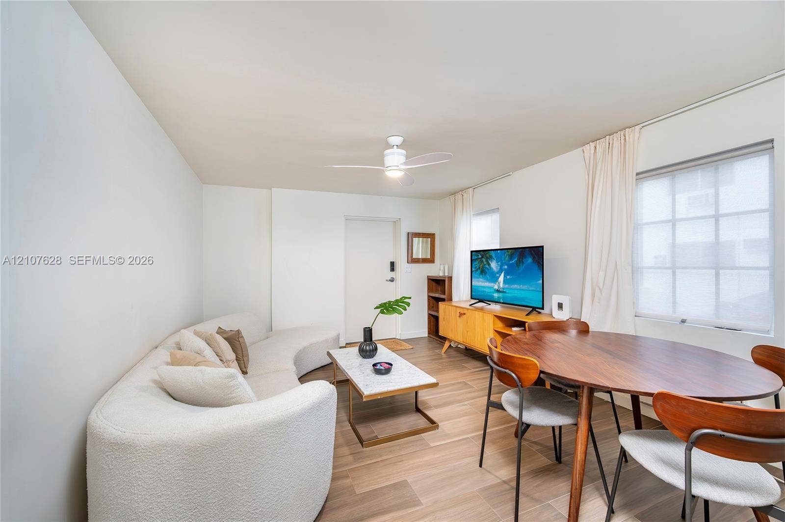 217 Madeira Avenue, #1, Coral Gables, Coral Gables, FL 33134 Living area featuring wood-finish flooring, a ceiling fan, and multi-pane windows