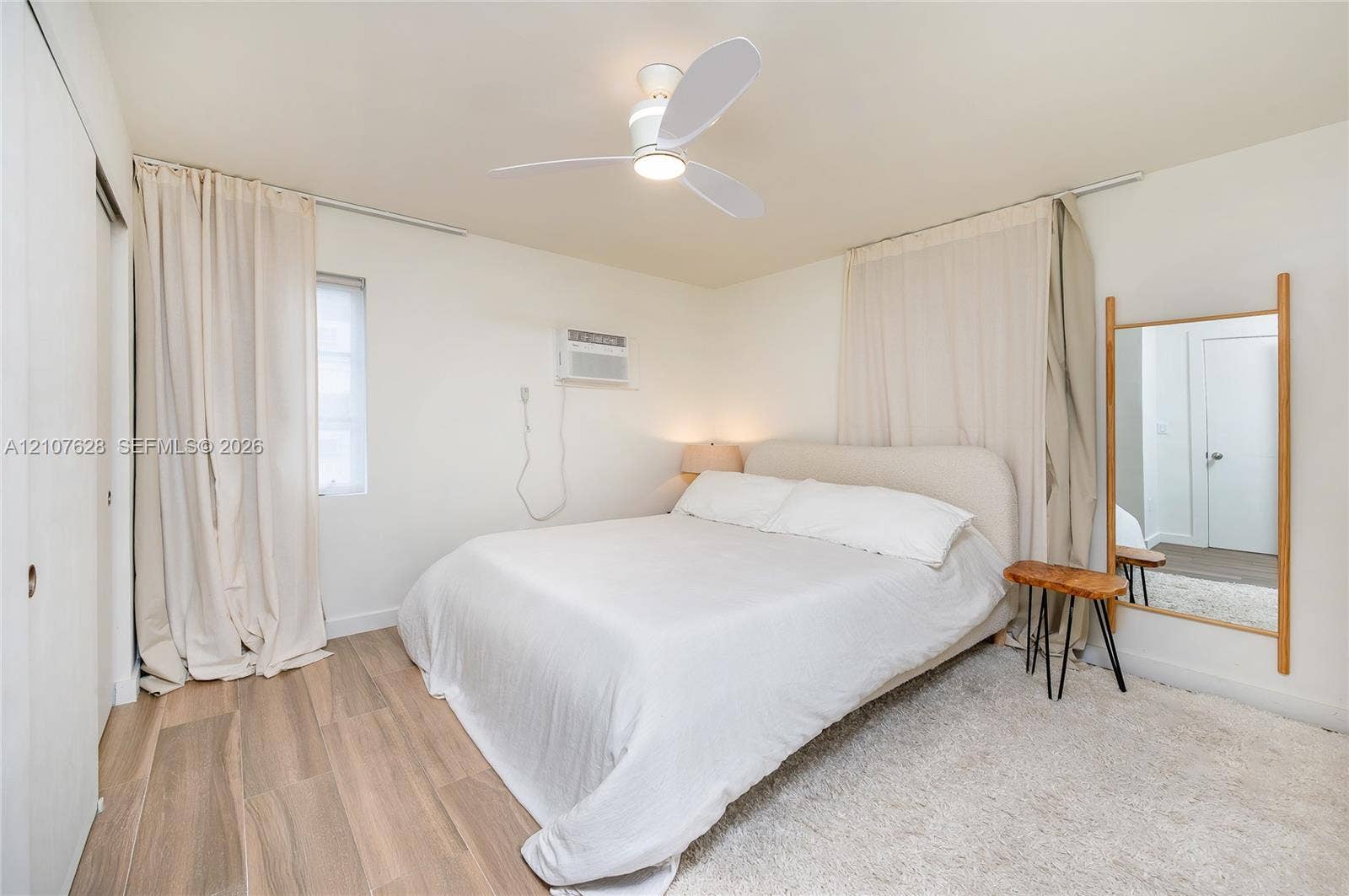 217 Madeira Avenue, #1, Coral Gables, Coral Gables, FL 33134 Interior room featuring wood-finish flooring, a contemporary three-blade ceiling fan, and a wall-mounted climate control unit