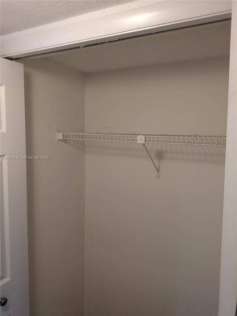 Closet featuring a white paneled door and installed wire shelving