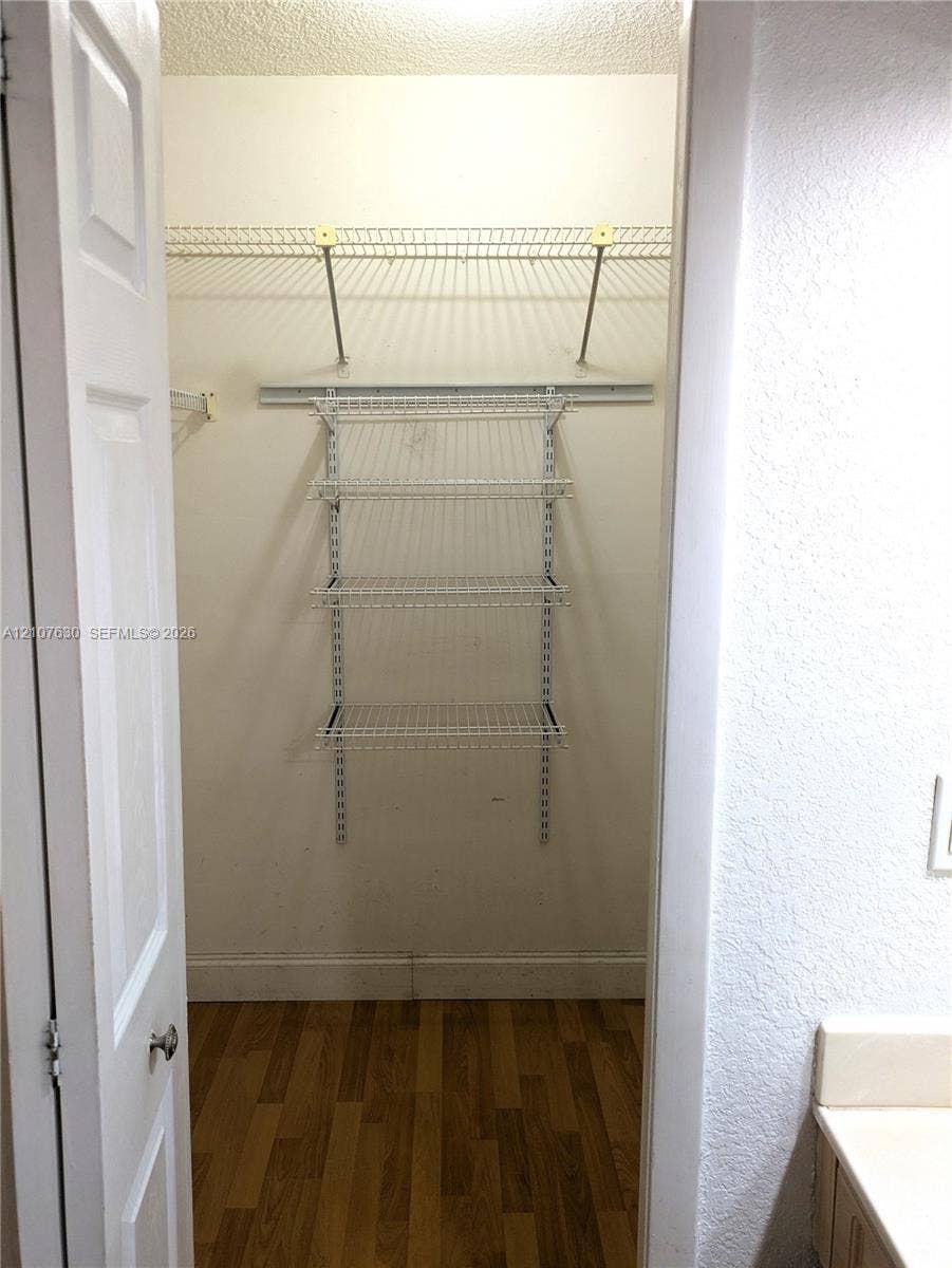 Storage area featuring wood-finish flooring and integrated white wire shelving systems