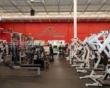 Expansive fitness facility featuring high-clearance open-truss ceilings, durable rubberized flooring, and floor-to-ceiling windows