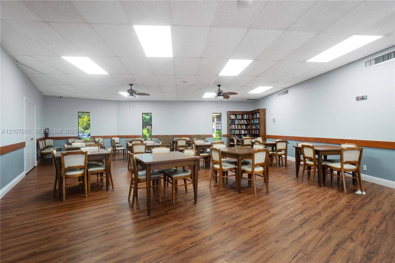 151 Berkley Road, #112, Hollywood, FL 33024 Wood-finish flooring, drop ceiling with recessed rectangular lighting, dual ceiling fans, and built-in shelving