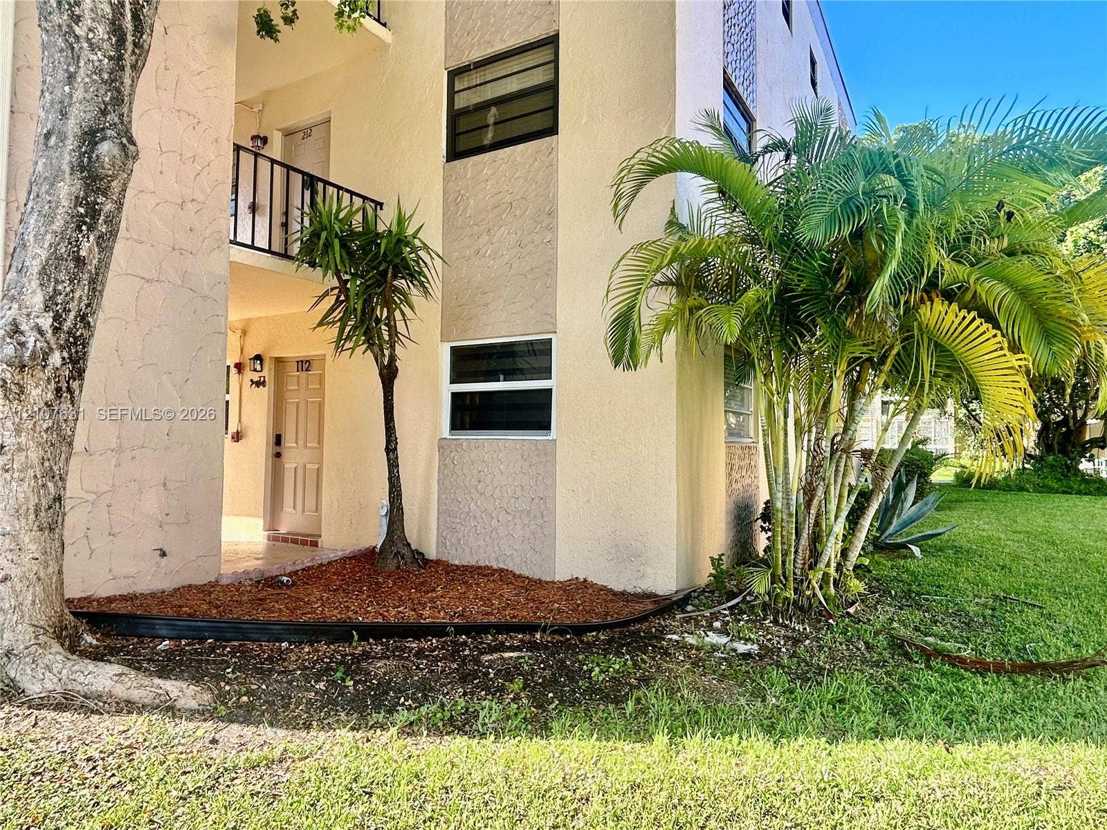 151 Berkley Road, #112, Hollywood, FL 33024 Stucco exterior with multi-level balconies, wrought iron railings, and integrated palm tree landscaping