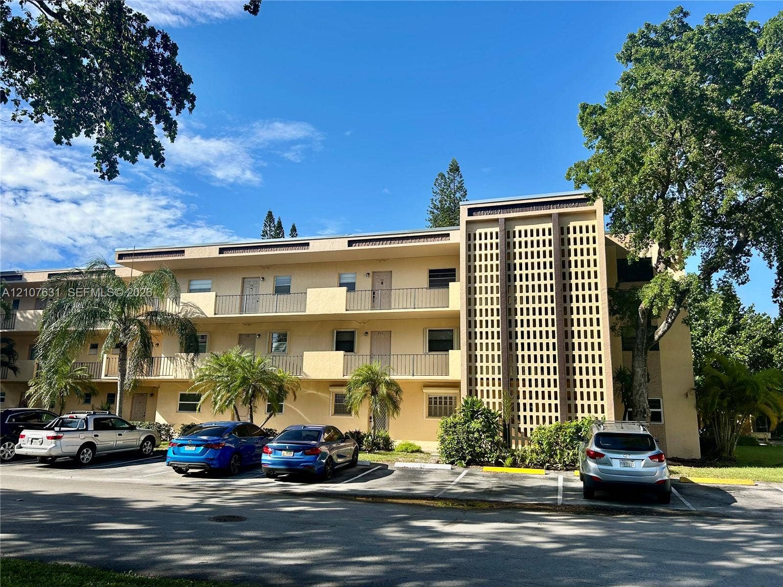 151 Berkley Road, #112, Hollywood, FL 33024 Multi-story exterior featuring stucco siding, decorative breeze block architectural detailing, and metal balcony railings