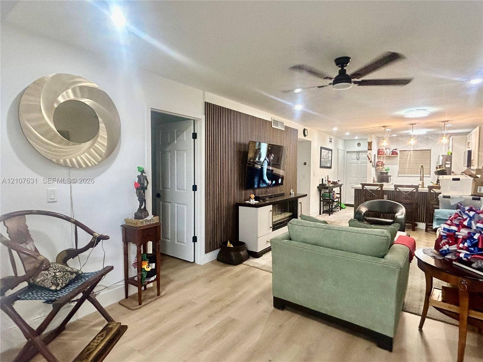 151 Berkley Road, #112, Hollywood, FL 33024 Open concept living area featuring wood-finish flooring, a vertical-slat accent wall, and recessed lighting