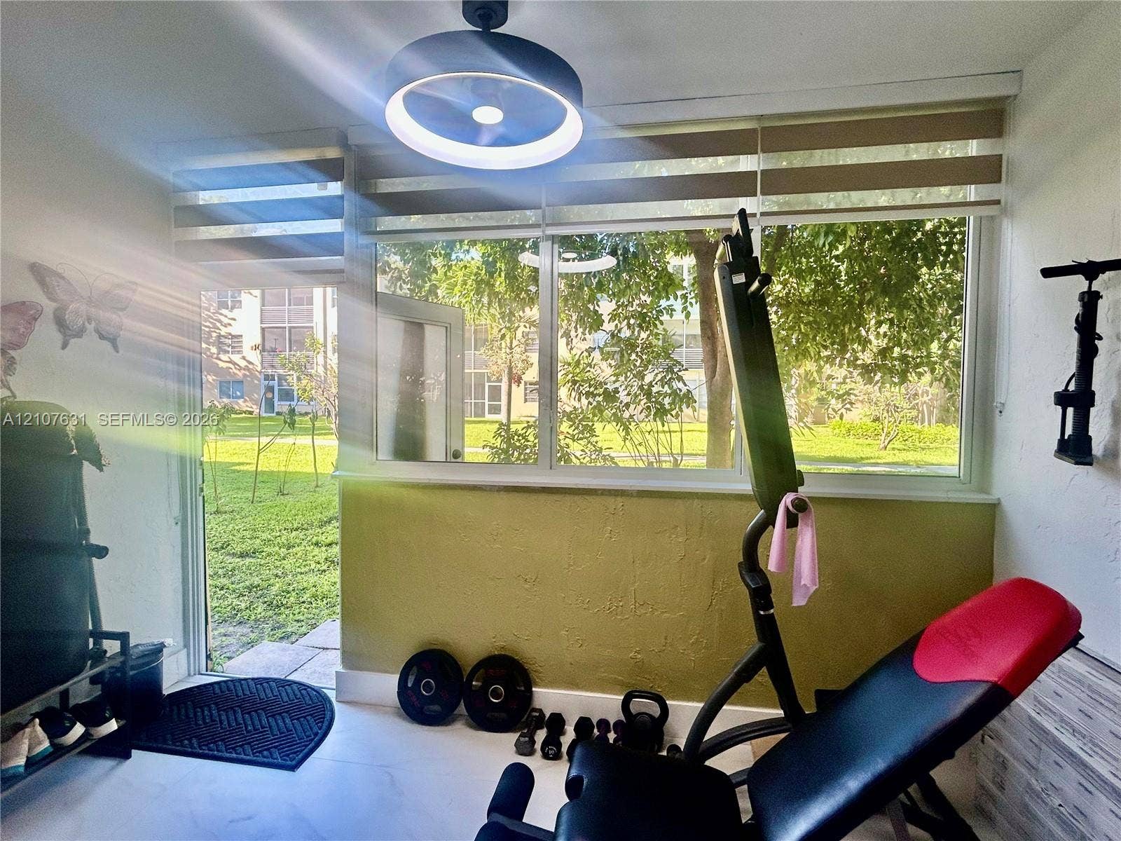 151 Berkley Road, #112, Hollywood, FL 33024 Multi-pane windows with integrated blinds, contemporary circular LED ceiling light fixture, and glass-paneled entry door