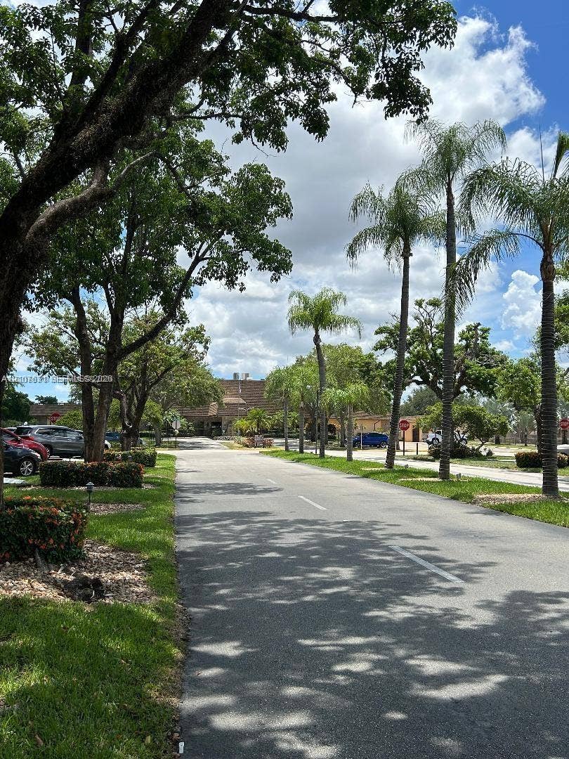 151 Berkley Road, #112, Hollywood, FL 33024 Paved street lined with mature trees, established palms, and curated landscaping