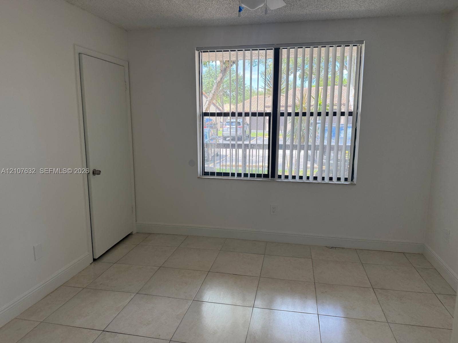 4501 W Mcnab Road, #13, Pompano Beach, Pompano Beach, FL 33069 Neutral-toned ceramic tile flooring, solid-core interior door, and large window with vertical blinds