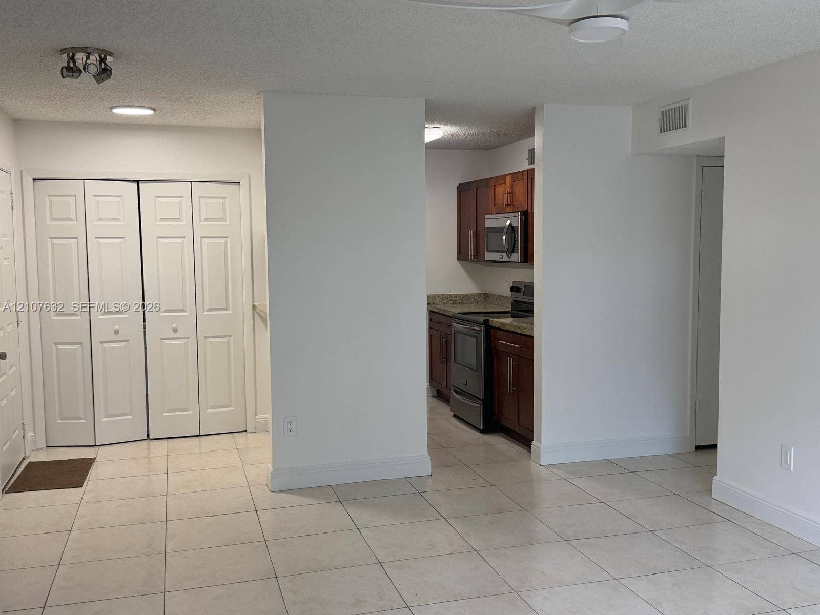 4501 W Mcnab Road, #13, Pompano Beach, Pompano Beach, FL 33069 Tile flooring, bi-fold closet doors, stainless steel kitchen appliances, wood cabinetry, and stone-finish countertops