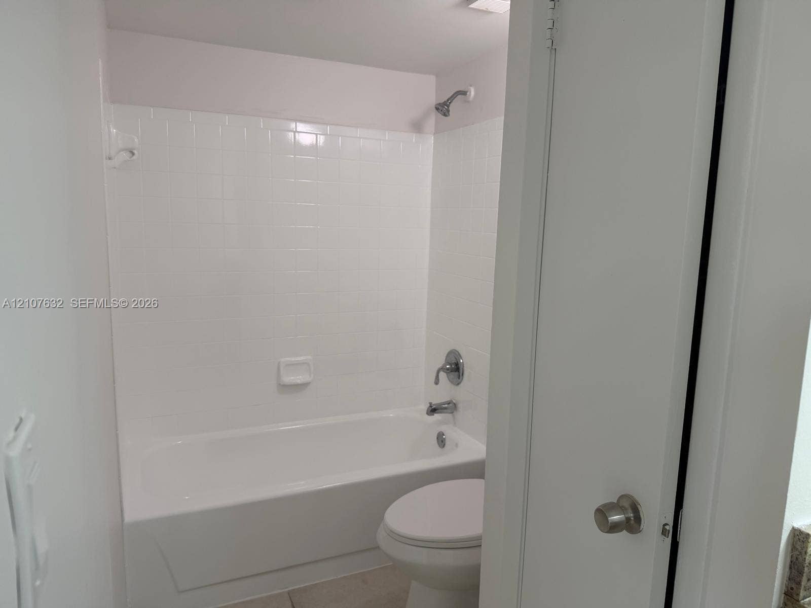4501 W Mcnab Road, #13, Pompano Beach, Pompano Beach, FL 33069 Bathroom featuring a porcelain tub with white ceramic tile surround, integrated soap dish, and polished chrome plumbing fixtures