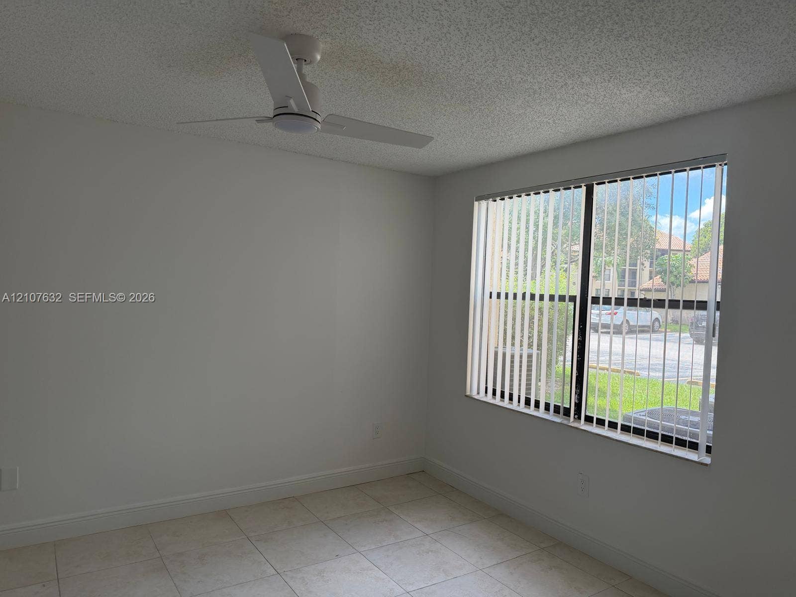 4501 W Mcnab Road, #13, Pompano Beach, Pompano Beach, FL 33069 Neutral interior space featuring tile flooring, a ceiling fan with integrated lighting, and vertical window blinds