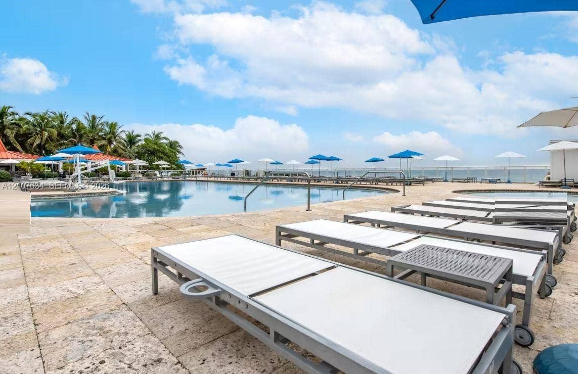 19201 Collins Avenue, #941, Sunny Isles Beach, FL 33160 Swimming pool with natural stone decking, integrated spa, and metal pool railings