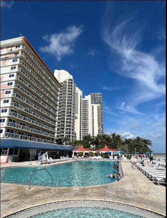 19201 Collins Avenue, #941, Sunny Isles Beach, FL 33160 In-ground swimming pool and attached hot tub with stone-tiled decking and covered patio area